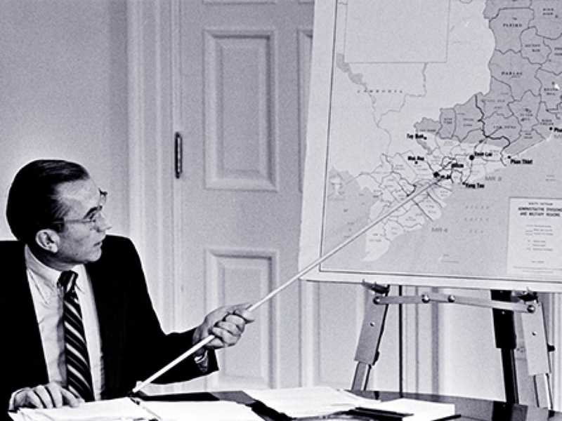 Image of a man using a pointer to identify a location on a map.