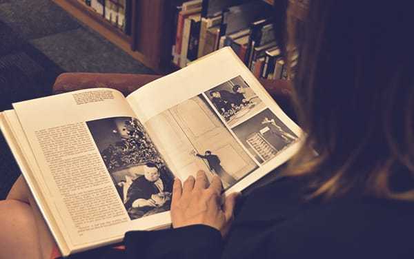 A photo of a student reading a book with large panel photographs of the CIA.
