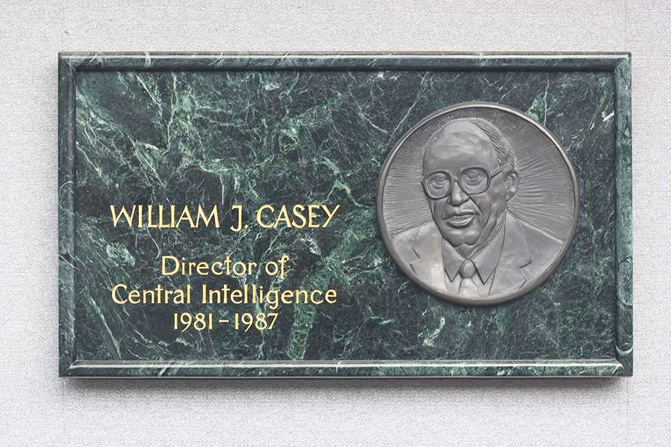 A plaque made of green stone with William J. Casey's name and portrait engraved in it.