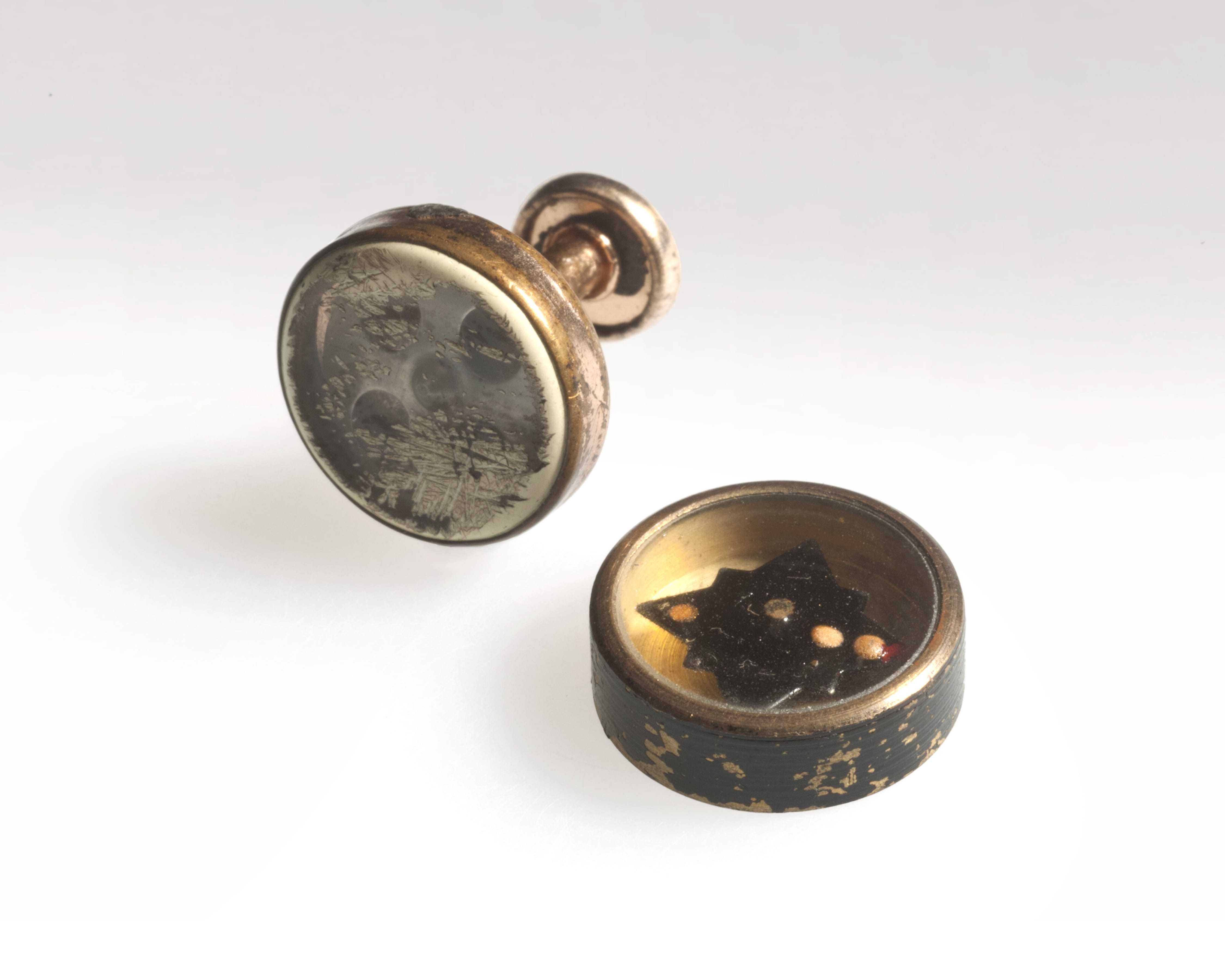 Two cufflinks that each contain a miniature compass