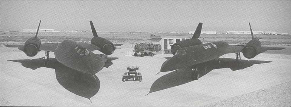 A black and white frontal shot of the OXCART beside the Blackbird aircrafts.