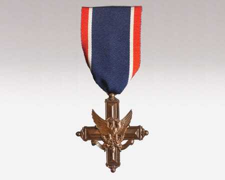A small red, white, and blue ribbon with a medal consisting of a cross and eagle
