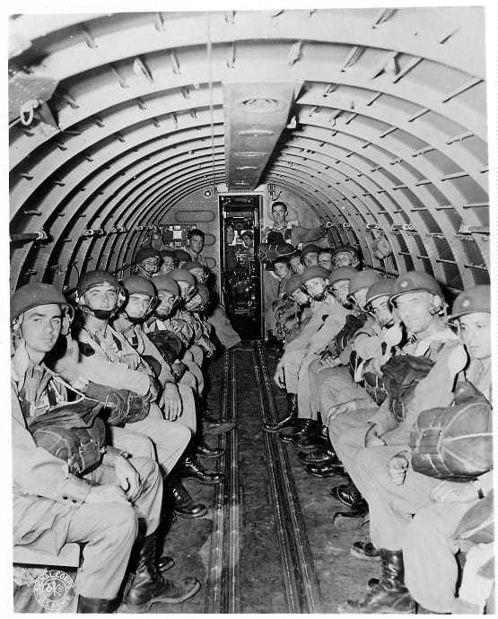 William Colby standing among OSS soldiers in a mission aircraft.