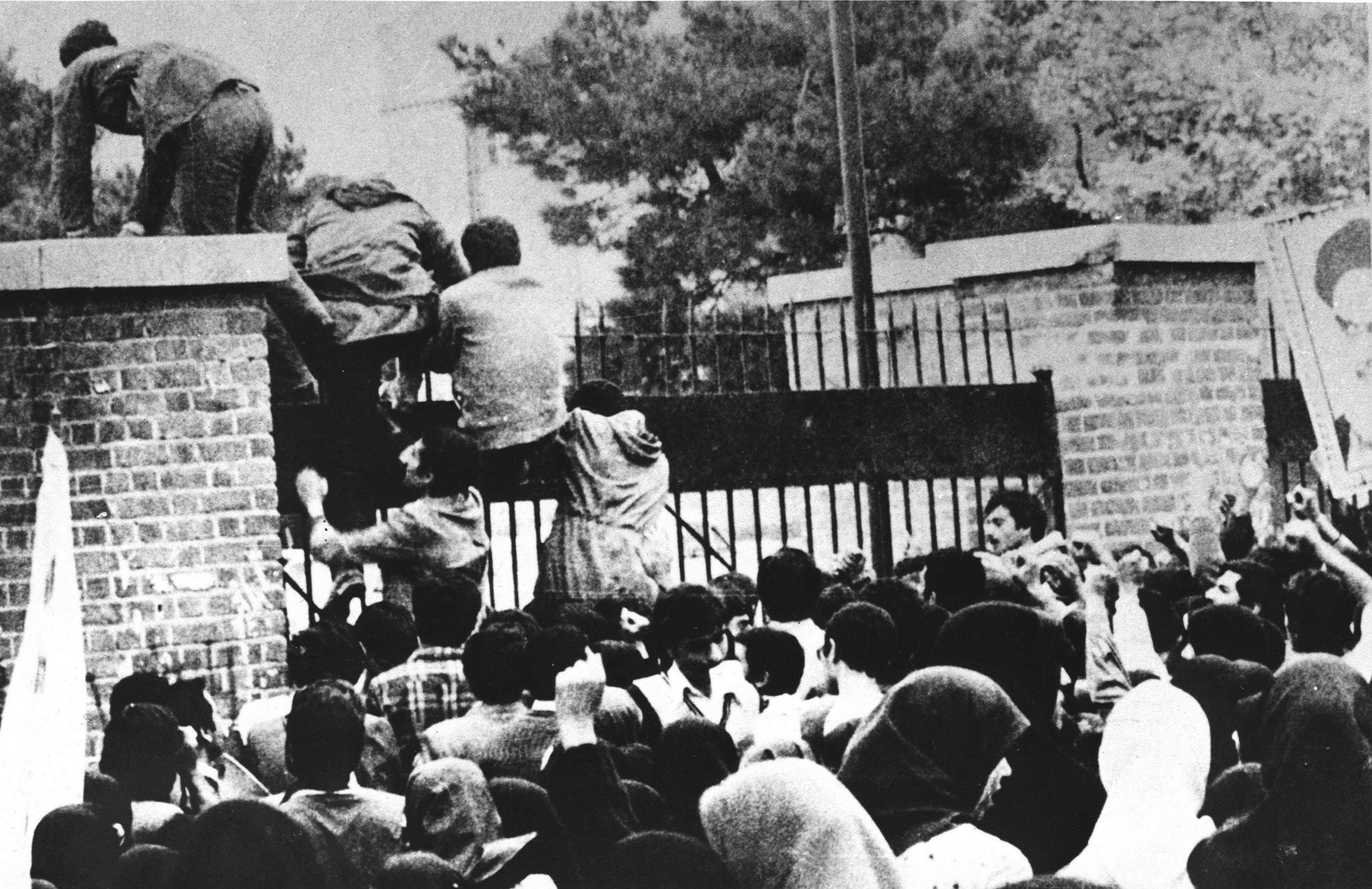 Iranian students climb over the wall of the U.S. Embassy in Tehran on November 4, 1979