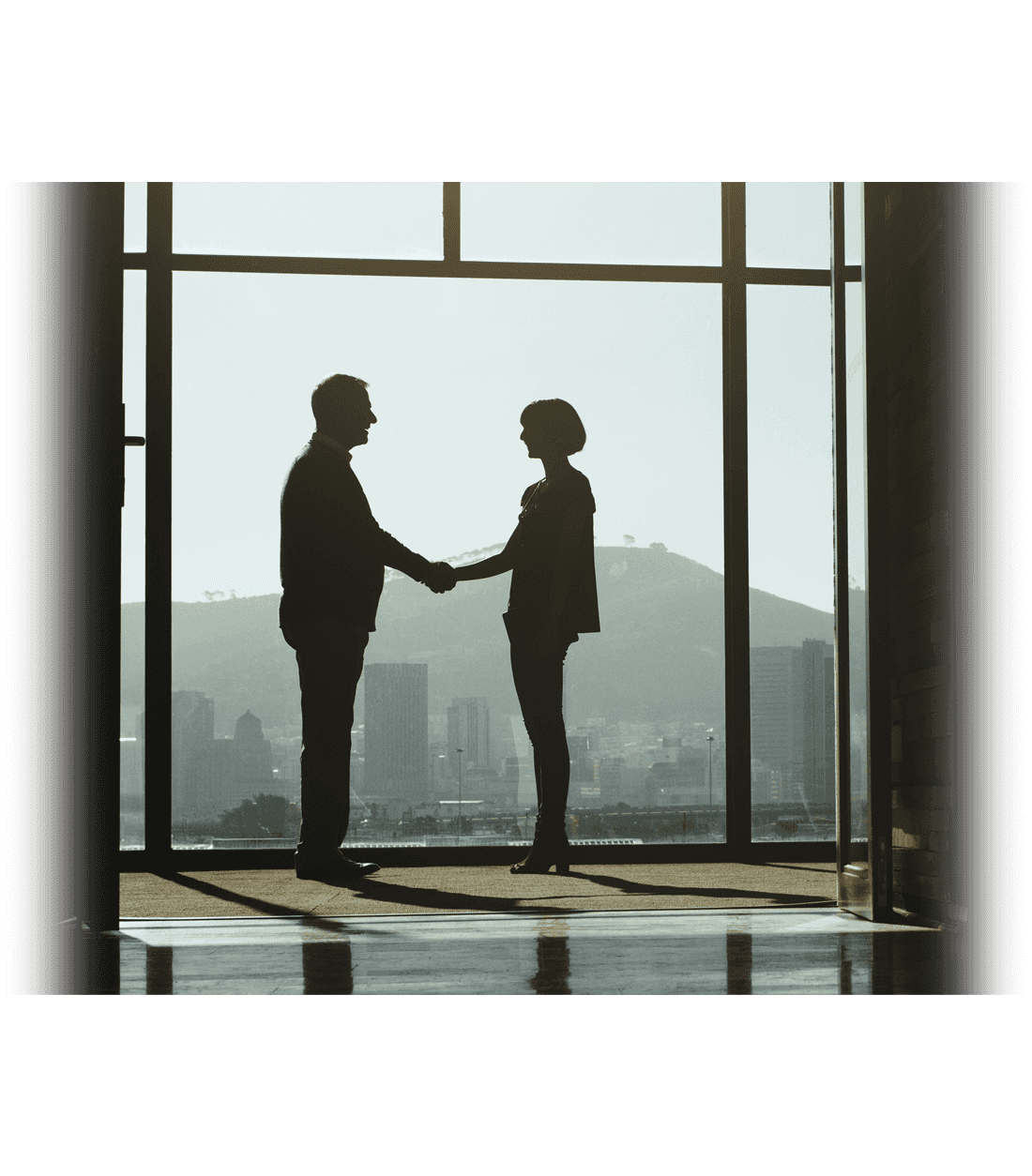 a woman and man shaking hands in front of a floor to ceiling window