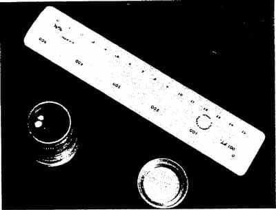 A black and white image of a ruler next to two glasses.