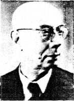 Closeup of a bald man with glasses looking to the right.