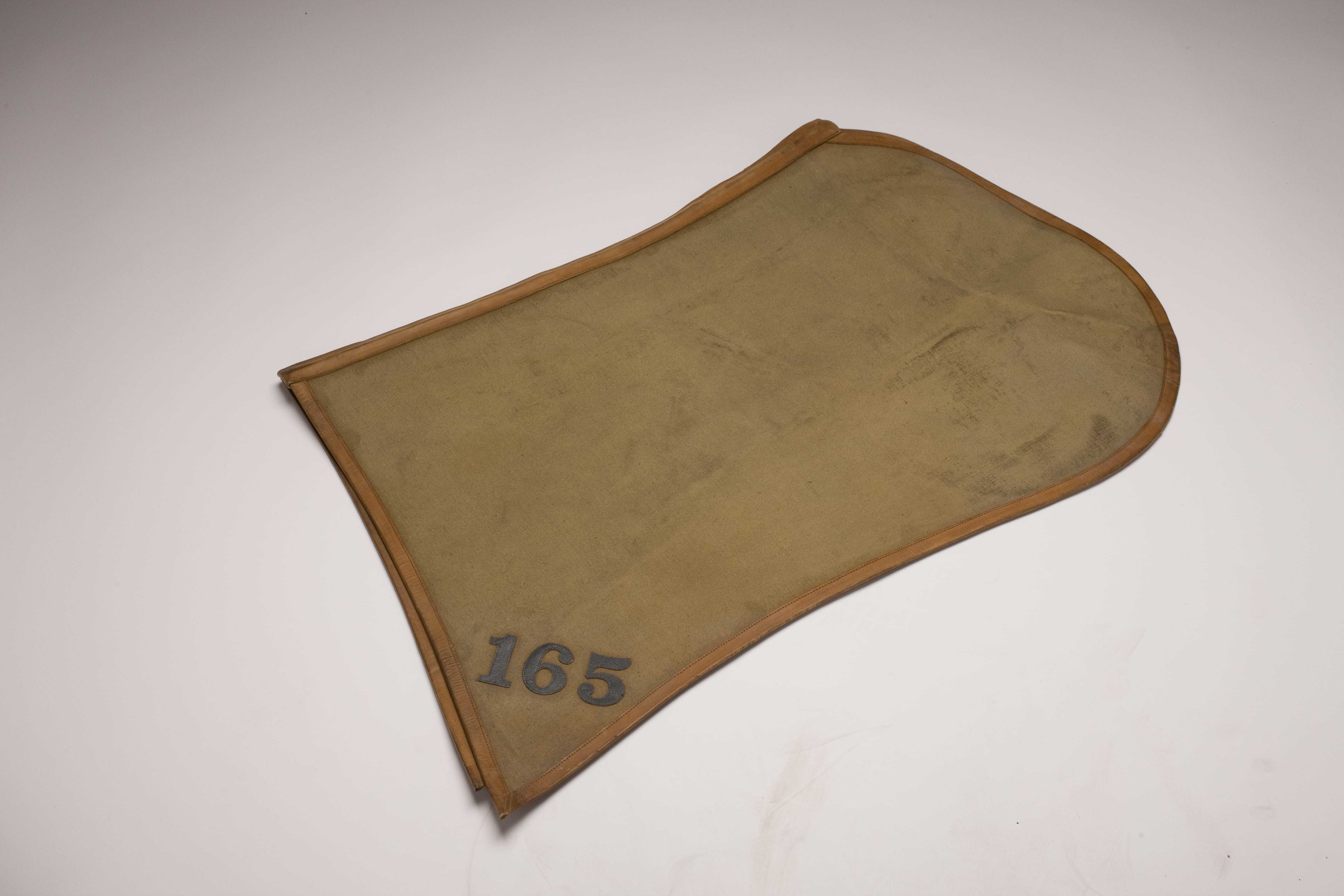 A worn yellow blanket with the number 165 written in the corner