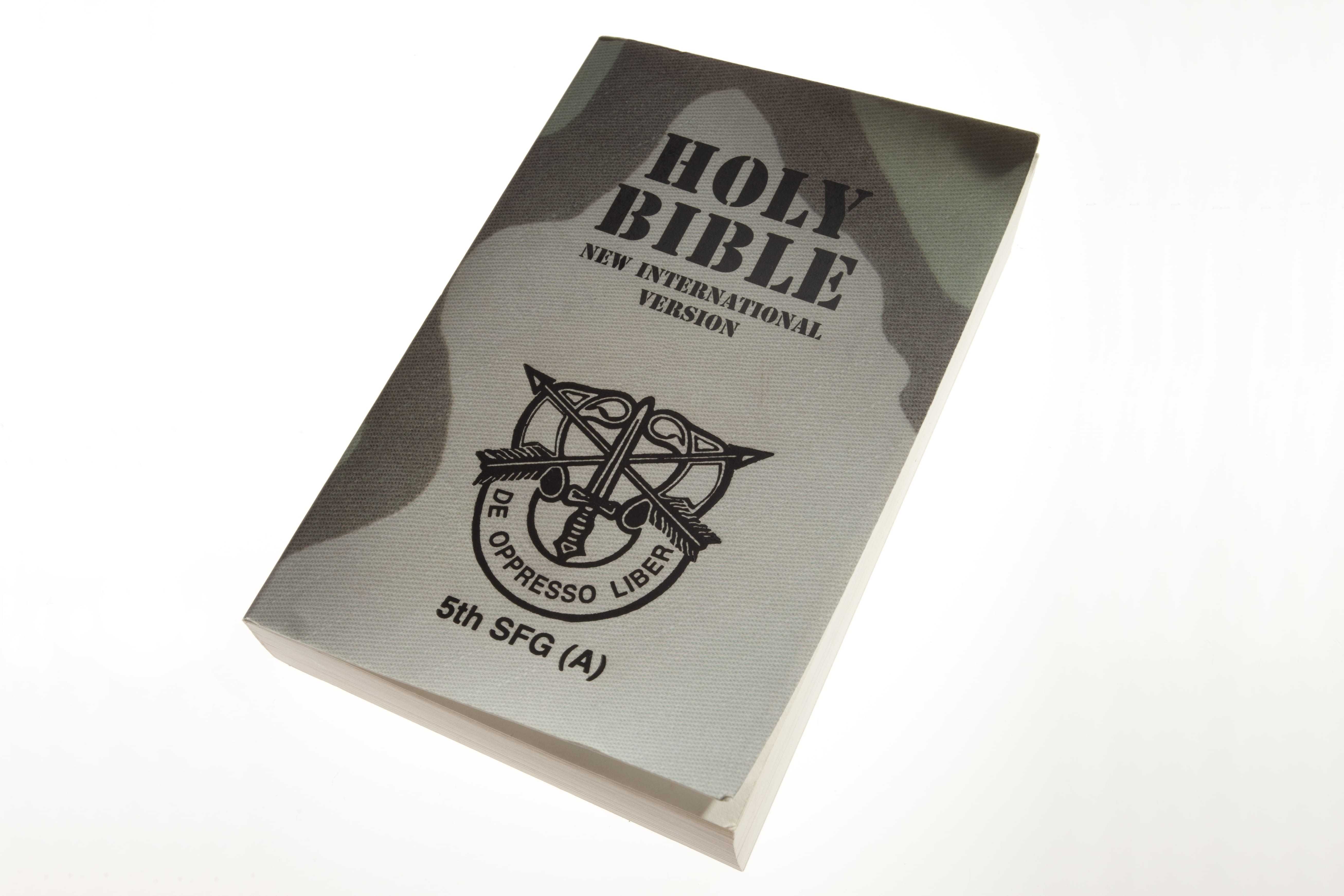 A Bible with a camouflage-print cover and the United States Army Special Forces insignia