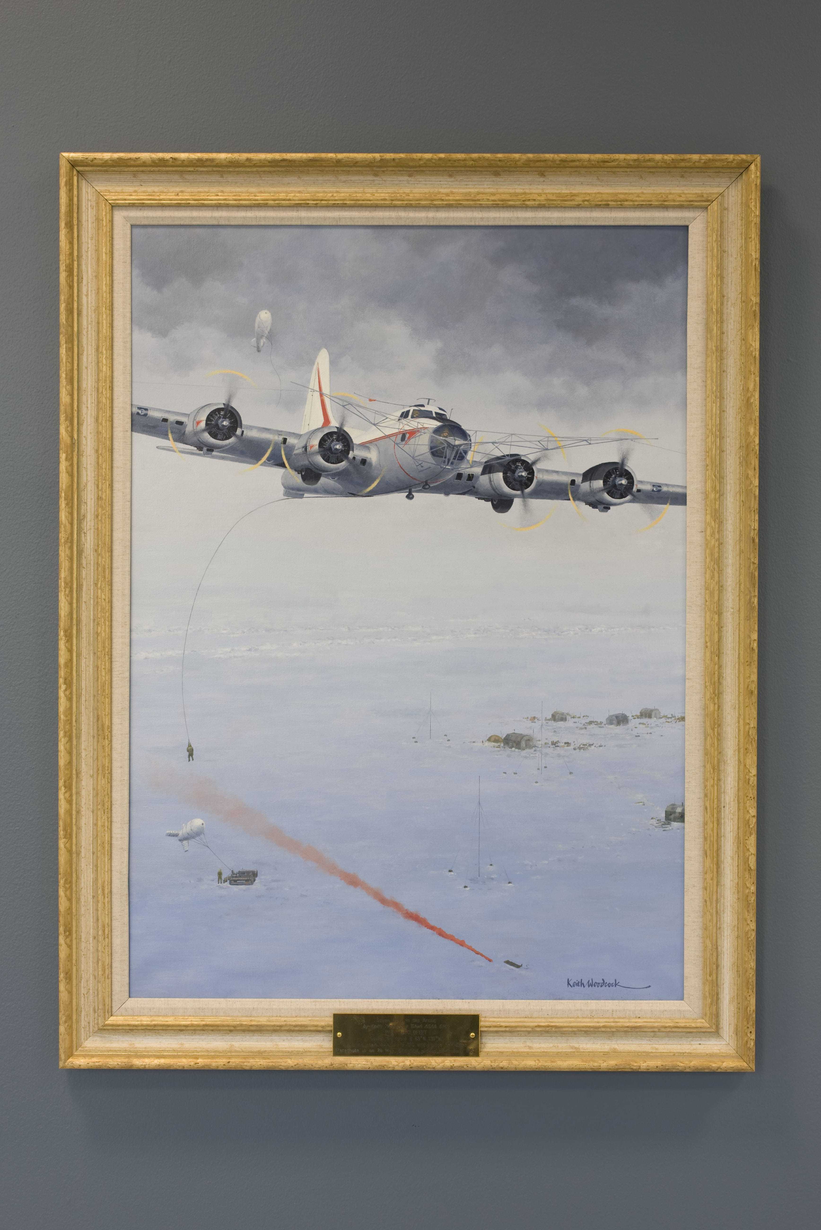 A framed oil painting showing a B-17 attempting to pick up two American soldiers, one still on the ground next to a red flare