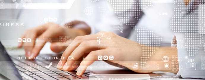 A close up of hands typing on a laptop keyboard with a transparent world map overlaying the image.