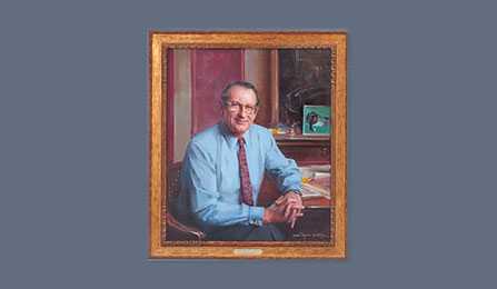 A portrait of former CIA director John M. Deutch in a gold frame.