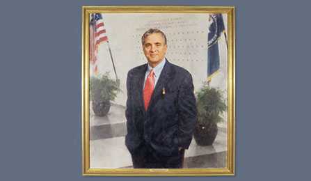 A portrait of former CIA director George J. Tenet in a gold frame.