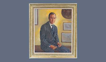 A portrait of former CIA director George H. W. Bush in a gold frame.