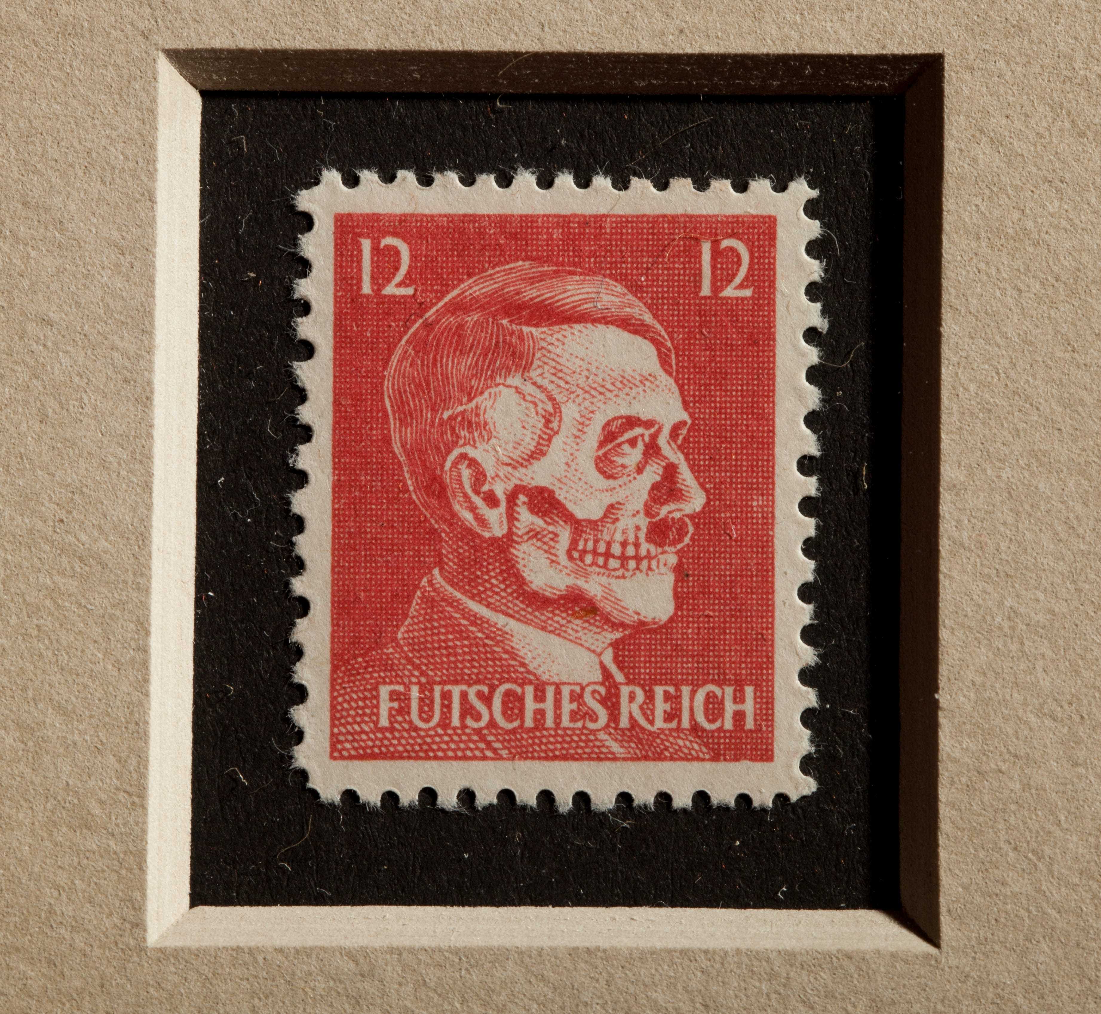 A rectangular postage stamp with a red background and white text. The image is a side profile of Adolf Hitler with a skeletal face.