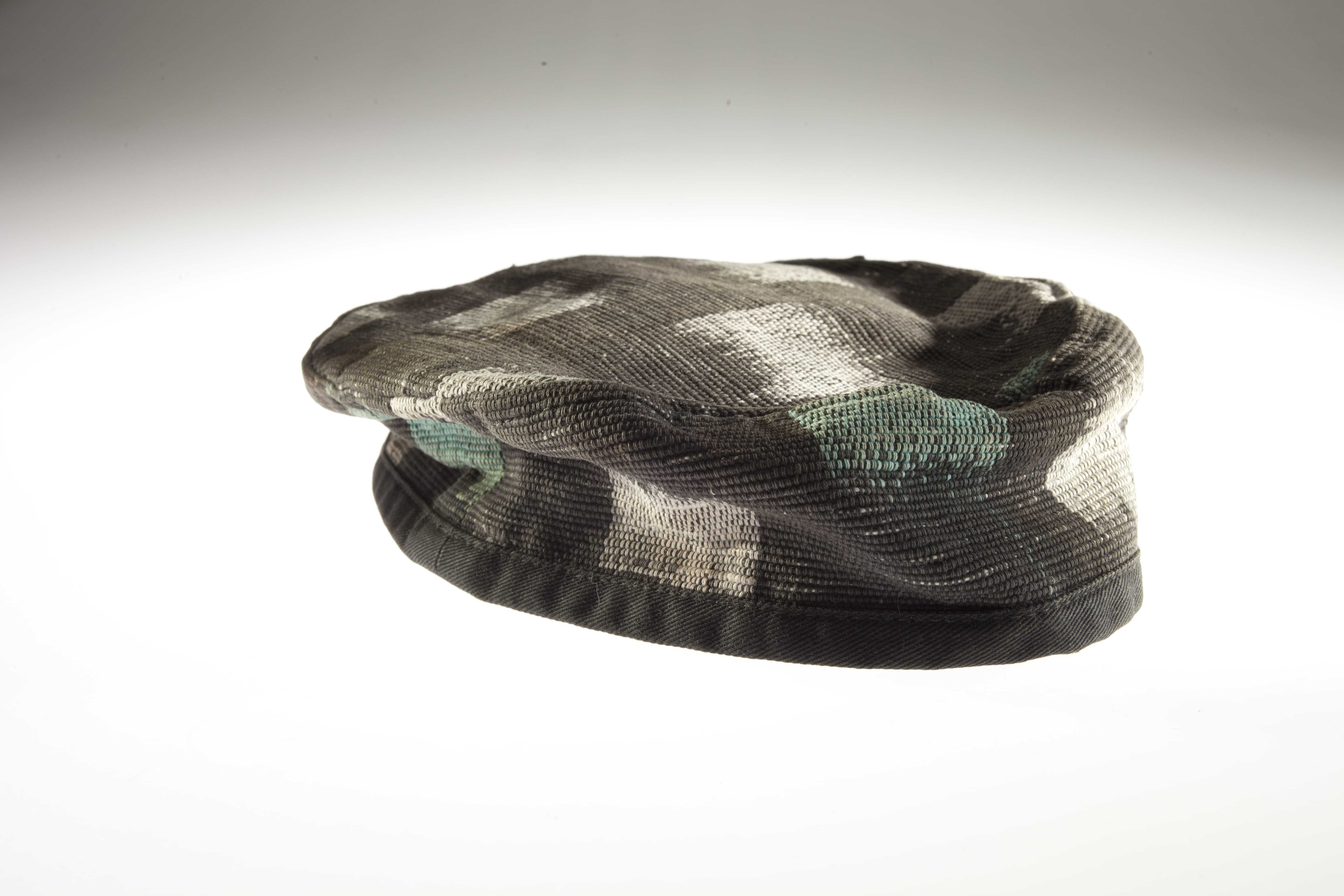 A small cap with a dark grey, teal, and white square pattern.