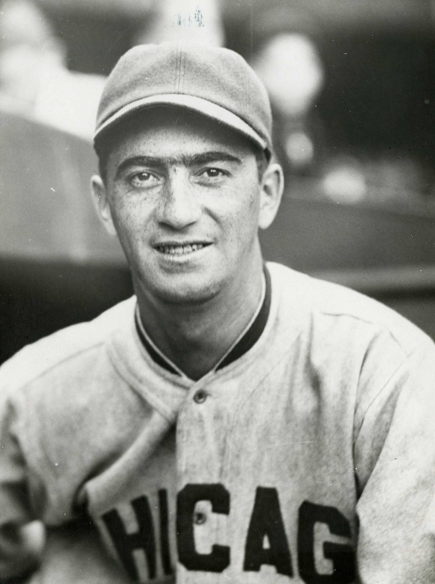 black and white portrait of man in baseball uniform looking at camera.