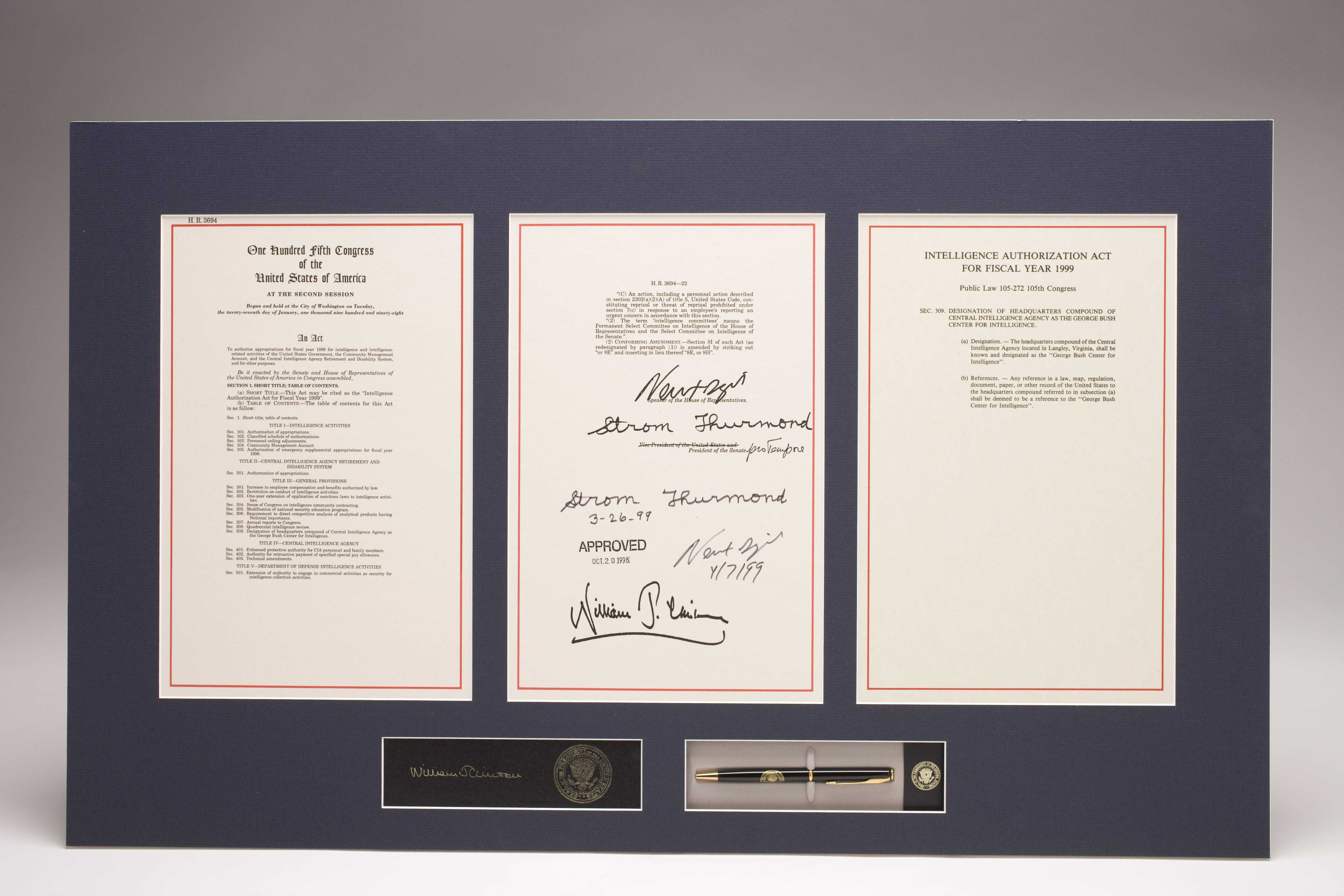 Three framed pages of the Intelligence Authorization Act, signed and dated by several people