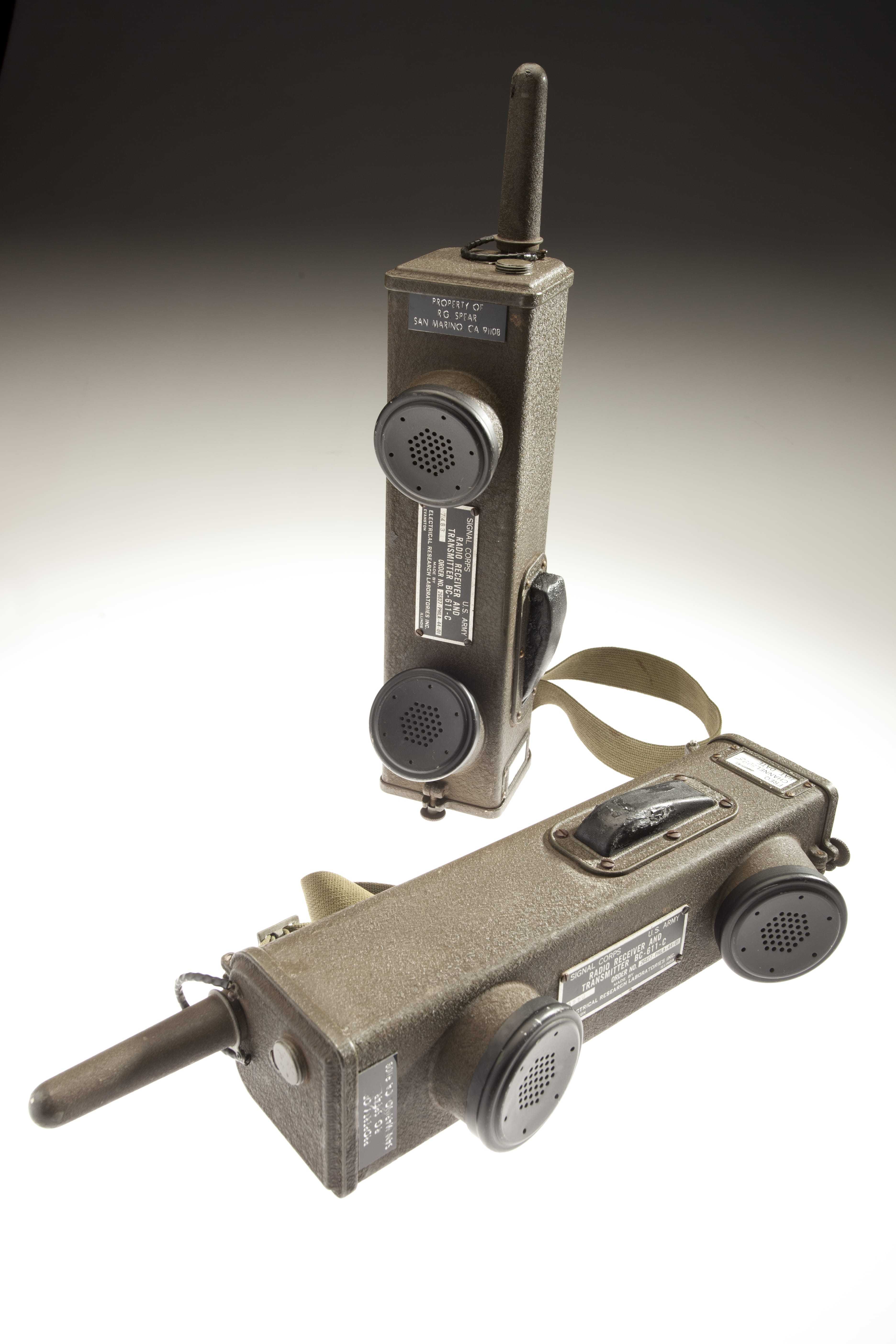 Two rectangular walkie-talkies, each with a mouthpiece and earpiece.