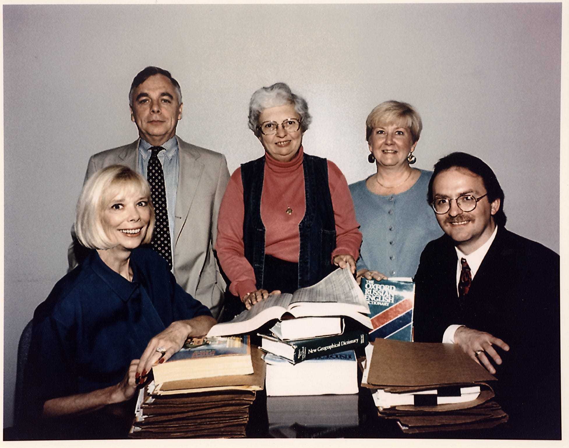 Jeanne Vertefeuille sitting at a desk surrounded by four officials.