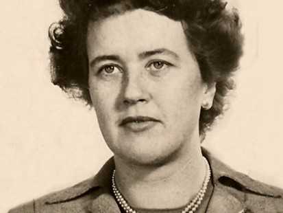 A sepia colored headshot of Julia Child, her gaze off in the distance.