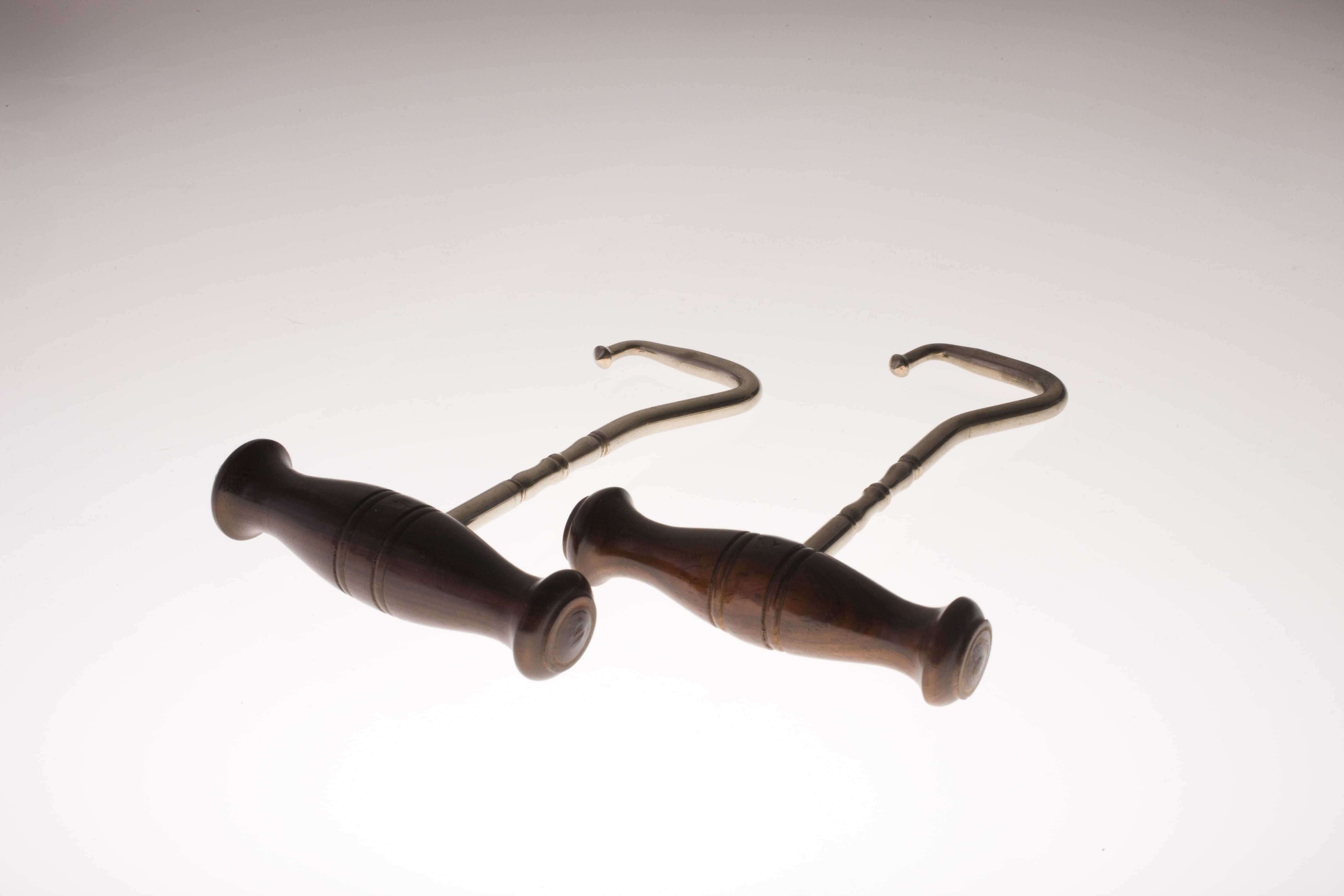 Two polished handles, each with gold u-shaped hooks