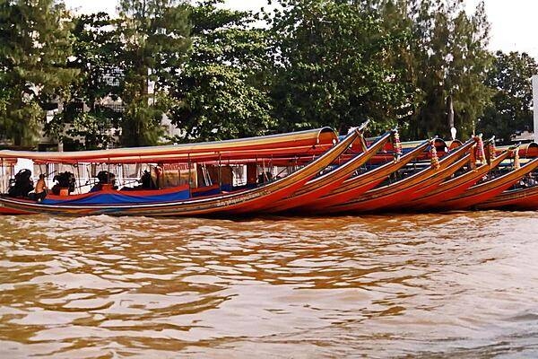 Sleek and colorful boats along a Bangkok canal.