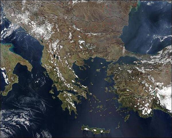 Countries shown in this late winter satellite image of the southern Balkan Peninsula include Italy (left center edge), Greece (below center), and Turkey (right edge). At upper right is the Black Sea, at center is the Aegean Sea, at upper left is the Adriatic Sea, and at bottom left is the Mediterranean Sea. North of Turkey are Bulgaria and Romania. Moving clockwise from top left are Croatia, Serbia, North Macedonia, and Albania. North of Albania is Montenegro and Bosnia-Herzegovina. Scattered fires appear as red dots. Image courtesy of NASA.