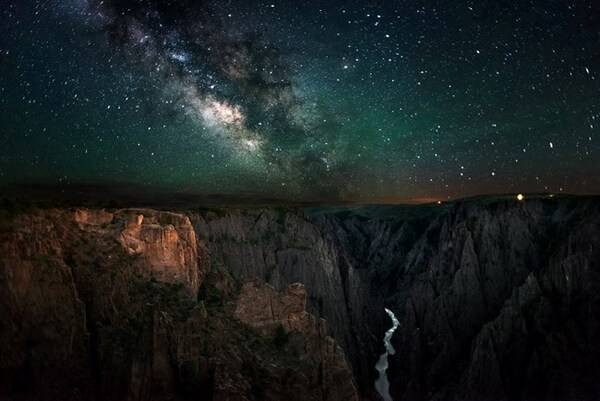 The Milky Way rises above sheer canyon cliffs at Black Canyon in Gunnison National Park, Colorado. Photo courtesy of the National Park Service/ G. Owens.