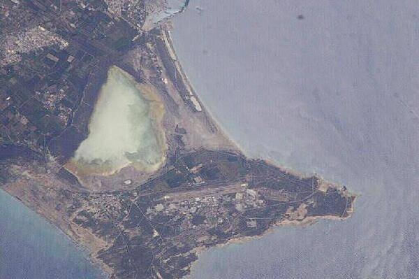 The salt lake on Akrotiri takes on a cloudy greenish-tan hue in this close-up view of the peninsula. The airfield appears prominently in the lower center. Image courtesy of NASA.