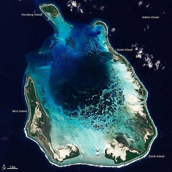 The Cocos (Keeling) Islands lie in the eastern Indian Ocean, about 2,900 km (1,800 mi) northwest of the Australian city of Perth. Comprised of coral atolls and islands, the archipelago includes North Keeling Island and the South Keeling Islands. This natural-color satellite image of the South Keeling Islands dates to 31 July 2009.

Coral atolls - which are largely composed of huge colonies of tiny animals - form atop islands. Over time the islands may subside, but the coral remains growing upward and generally forming complete or partial rings. Only some parts of the South Keeling Islands still stand above the water surface. In the north, the ocean overtops the coral.

Along the southern rim of this coral atoll, the shallow water appears aquamarine. The water darkens to navy blue as it deepens toward the central lagoon. Above the water line, coconut palms and other plants form a thick carpet of vegetation.

In 2005, the Australian Government issued a report on the Cocos (Keeling) Islands, summarizing field research conducted between 1997 and 2005. Overall, the report noted, &quot;the coral reef community at Cocos (Keeling) Islands is very healthy and in a stable period, with little impact from anthropogenic activities.&quot; Image courtesy of NASA.