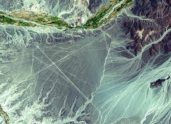 The Nasca Lines, located in the desert coastal plain of Peru 400 km south of Lima, were first observed in the 1920s when commercial airlines began operating in the area. Clearly seen from the air, the Lines were made by removing the iron-oxide coated pebbles which cover the surface of the desert. The lighter shade of the exposed ground contrasts with the color of the gravel. South of the Nasca Lines, archaeologists have now uncovered the lost city of the Line-builders. Known as Cahuachi, it was built nearly 2,000 years ago and was mysteriously abandoned 500 years later.
Image courtesy of NASA.