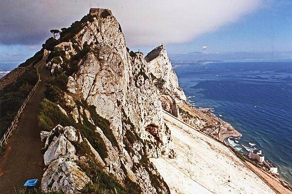 Looking north along the crest of The Rock of Gibraltar one can see just how narrow the rock formation is. The coast of Spain is visible in the background.