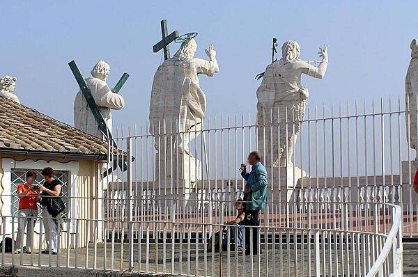 Behind the statues surmounting the facade of St. Peter&apos;s Basilica.