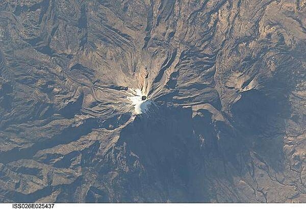 The snow and ice-clad peak of Pico de Orizaba (also known as Citlaltepetl) boasts a summit elevation of 5,675 m (18,619 ft) above sea level, making it the highest peak in Mexico and North America?s highest volcano. It is also one of three volcanic peaks in Mexico - together with Popocatepetl and Iztaccihuatl - that retain summit glaciers. Pico de Orizaba is part of the Trans-Mexican Volcanic Belt that extends roughly east-west across Mexico. The last recorded eruption took place in 1846; while the volcano is considered dormant at present, geologists continue to investigate the potential hazards associated with a renewal of activity. Shadows accentuate several features of the Pico de Orizaba stratovolcano visible in this photograph from the International Space Station. The 300-meter-deep summit crater is clearly visible against surrounding ice and snow cover at center. Several lava flows extend down the flanks of the volcano, made readily visible by prominent cooling ridges along their sides known as flow levees. One of the most clearly visible examples is located on the southwest flank of the cone. The extinct Sierra Negra volcano to the southwest has a summit elevation of 4,640 m (15,223 ft) above sea level; while not as lofty as Pico de Orizaba, it is also one of Mexico?s highest peaks. Image courtesy of NASA.