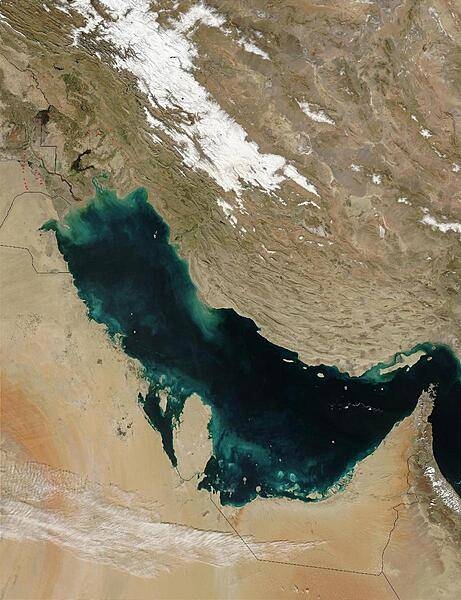 Much of the sediment clouding the water in this image of the Persian Gulf is from the Shatt al Arab River, which enters the Gulf in the north along the Iran-Iraq border. The river drains the combined waters of the Euphrates and Tigris Rivers of Iraq, and the Karun River of Iran. Though other rivers empty into the Persian Gulf, most of its fresh water comes from the Shatt al Arab. On the right edge of the image is the narrow Strait of Hormuz, which connects the Persian Gulf to the Arabian Sea, part of the northern Indian Ocean. The Persian Gulf is flanked to the west by wedge-shaped Kuwait and by Saudi Arabia with its vast tan-, pink-, and white-sand deserts; to the south by Qatar, the United Arab Emirates, and Oman; and to the east by the dry mountains of Iran. The wetlands and rivers of Mesopotamia border the Gulf on the north. The red dots mark gas flares in oil fields of Iran and Iraq. Image courtesy of NASA.