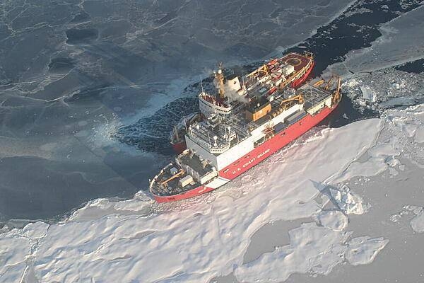 Helicopter view of Canadian Coast Guard Ship Louis S. St. Laurent (top) and U.S. Coast Guard Cutter Healy (bottom) on the Arctic Ocean. This rendezvous took place during a scientific expedition to map the extended continental shelf in the Arctic Ocean. Photo courtesy of the US Geologic Survey/ Jessica K. Robertson.