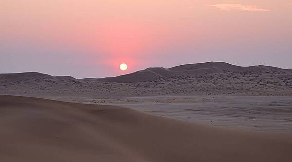 The Namibian desert landscape stretches as far as the eye can see in this image of a sunset at Gobabeb. The sky changes colors as the sun sinks behind the dunes in the west. Photo courtesy of NASA.