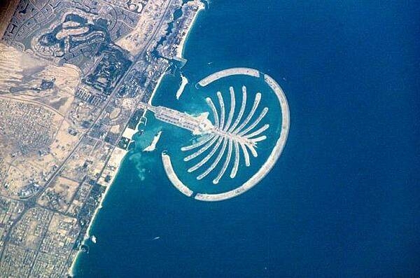 The artificial peninsula and islands that make up Palm Jumeirah in Dubai as seen from the International Space Station. This massive earthwork is reclaimed from Dubai&apos;s Persian Gulf coast. Advertised as &quot;being visible from the Moon,&quot; the palm-shaped structure displays 17 huge fronds framed by an 11-km (7 mi) protective barrier. It is the first of three residential and commercial palm-shaped projects being undertaken in Dubai. Image courtesy of NASA.