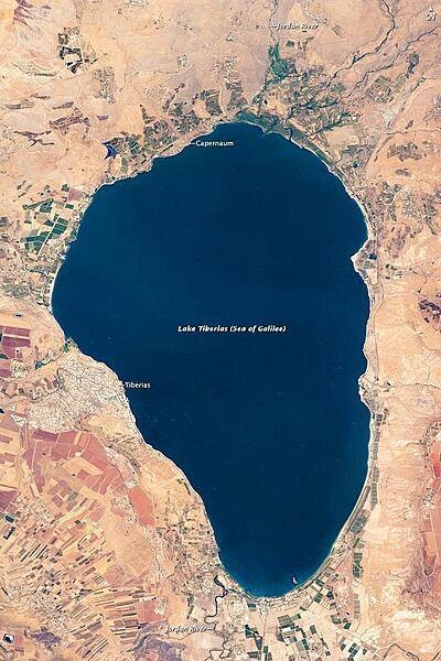 Israel&apos;s largest freshwater lake, Lake Tiberias, is also known as the Sea of Galilee. The lake measures just over 21 km (13 mi) north-south, and it is only 43 m (141 ft) deep. The lake is fed partly by underground springs related to the Jordan sector of the Great Rift Valley, but most of its water comes from the Jordan River, which enters from the north. The river&apos;s winding course can be seen draining the south end of the lake at image bottom. Angular green and brown field patterns clothe most hillsides in this arid landscape. Bright roof tops are the hallmark of several villages in the area. Much of the area to the east of the lake is part of the Israeli-occupied Golan Heights. Image courtesy of NASA.