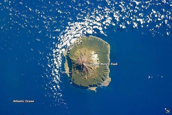 The shoreline of the 13 km (8 mi) wide island of Tristan da Cunha is marked on most sides by steep cliffs, with lower beach areas on the southern and north-northwestern sides. The island is notable for its bird population and includes important breeding grounds for petrels, albatrosses, penguins, and shearwaters. 
Tristan da Cunha is a shield volcano, a volcanic structure with a low, broad profile and composed of silica-poor lavas (such as basalt). The upper surface of this low base appears dark green in this astronaut photograph of 6 February 2013. Steeper brown to tan colored slopes mark the central cone of the volcano at the island&apos;s center. The summit crater, Queen Mary&apos;s Peak, sits at an elevation of 2,060 m (6,760 ft) above sea level. While geologic evidence indicates that eruptions have occurred from the central crater, lavas have also erupted from flank vents along the sides of the volcano and from smaller cinder cones. 
The last known eruption of Tristan da Cunha took place in 1961-1962 and forced the evacuation of the only settlement on the island, Edinburgh of the Seven Seas, on the northern coastline (obscured by clouds in this image). The town is considered to be the most remote permanent settlement on Earth, with its nearest neighbor located 2,173 km (1,347 mi) to the northeast on the island of St. Helena. Image courtesy of NASA.