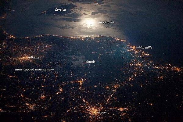 The brightly lit metropolitan areas of Torino (Italy), Lyon, and Marseille (both in France) stand out amidst numerous smaller urban areas in this dramatic photo from the international space station. The image captures the nighttime appearance of the France-Italy border. The southwestern end of the Alps Mountains separates the two countries. The island of Corsica is visible in the Ligurian Sea to the south (image top). The full moon reflects brightly on the water surface and also illuminates the tops of low patchy clouds over the border (center). Photo courtesy of NASA.