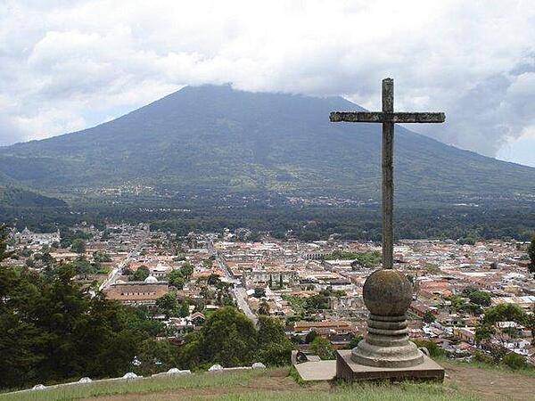 A cross overlooks the city of Antigua in the central highlands of Guatemala; the Volcan de Agua (Volcano of Water) appears in the background.