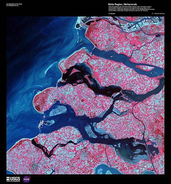 Along the southern coast of the Netherlands, sediment-laden rivers have created a massive delta of islands and waterways in the gaps between coastal dunes. The area in this false-color satellite image is extensively farmed, giving the photo its patchwork look. The Dutch have built an elaborate system of dikes, canals, dams, bridges, and locks to hold back the North Sea because of rising sea levels and devastating historic floods. The Dutch coastline has changed significantly over time due to these floods, such as the 1134 storm that formed the Zeeland archipelago when water covered massive swaths of land. Other major floods include St. Lucia&apos;s Day flood in 1287, St. Elizabeth&apos;s Day flood in 1421, and a massive flood in 1953 that sparked the building of the Delta works system in place today. The Delta works will be under stress in coming years as sea levels continue to rise. Image courtesy of USGS.