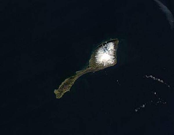 Tiny Jan Mayen Island sits about 1,040 km (650 mi) northeast of Iceland between the Norwegian and Greenland Seas. Covering 377 sq km (146 sq mi), the island is about twice the size of Washington, D.C. The white peak on the northeast section of the island is Haakon VII Toppen/Beerenberg, the northernmost active volcano in the world. Image courtesy of NASA.