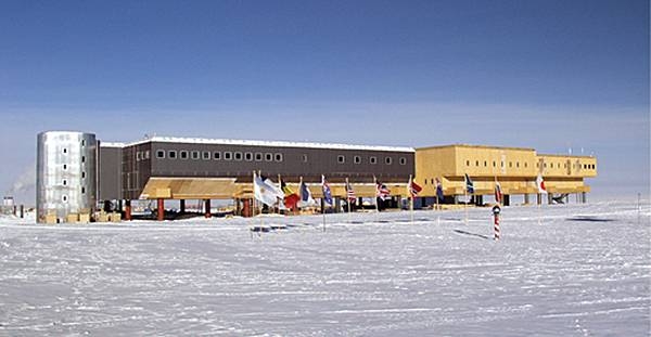A view of the Amundsen-Scott South Pole Station. Even though built on stilts to prevent snow accumulation, some annual snow buildup does occur (about 20 cm (8 in) per year). The station can be elevated to prevent its becoming buried in the snow. In the foreground is the ceremonial South Pole and the flags for the original 12 signatory nations to the Antarctic Treaty. Image courtesy of the National Science Foundation.
