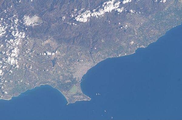 The Sovereign Base Area of Akrotiri juts into the Mediterranean Sea in this astronaut photo from 2003. The salt lake appears green in this image; the gray area further north is the Cypriot city of Limassol. Image courtesy of NASA.