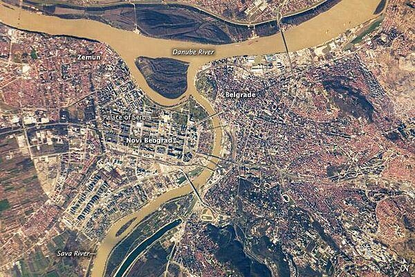 Belgrade, located at the confluence of the Danube and Sava Rivers, is the capital of the Republic of Serbia. The core of old Belgrade - known as Kalemegdan - is located along the right banks of both the Danube and the Sava Rivers (image center). To the west across the Sava, Novi Beograd (New Belgrade) was constructed following World War II. The difference in urban patterns between the older parts of Belgrade and Novi Beograd is striking in this astronaut photograph from the International Space Station. Novi Beograd has an open grid structure formed by large developments and buildings such as the Palace of Serbia - a large federal building constructed during the Yugoslav period, now used to house elements of the Serbian Government. By contrast, the older urban fabric of Belgrade is characterized by a denser street grid and numerous smaller structures.

Other suburban and residential development (characterized by red rooftops) extends to the south, east, and across the Danube to the north. The location of Belgrade along trade and travel routes between the East and West contributed to both its historical success as a center of trade and its fate as a battleground. Today, the city is the financial center of Serbia, while Novi Beograd supports one of the largest business districts in southeastern Europe. Image courtesy of NASA.
