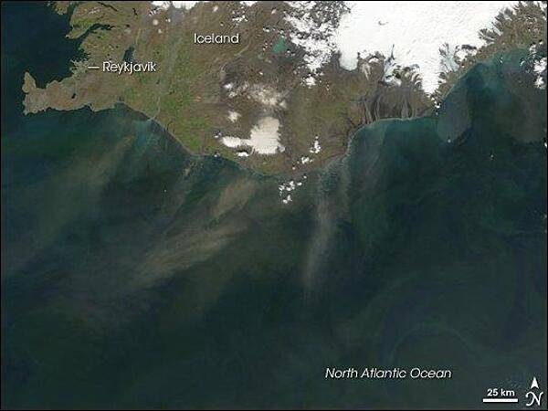 Plumes of dust blowing off the southern coast of Iceland in late June 2007. The dust appears as grayish blurs emanating from the coast southward over the North Atlantic Ocean. Blue-green algal blooms also fringe the coastline. Relatively light winter snow in 2006-07 followed by arid spring weather created the conditions for this dust storm. Photo courtesy of NASA.