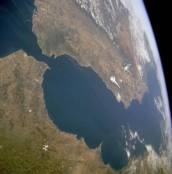 The Strait of Gibraltar provides a natural physical barrier between the countries of Spain (north) and Morocco (south). This photo shows the mountainous northern coast of Morocco and the coastal mountains of southern Spain, including the dagger-shaped, snow-covered Sierra Nevada Mountains of southeastern Spain. The British territory of Gibraltar is located on the thin, wedge-shaped peninsula on the east side of the bay in the southernmost protrusion of Spain. The city of Ceuta is a Spanish enclave on the extreme northeastern coast of Morocco. Image courtesy of NASA.